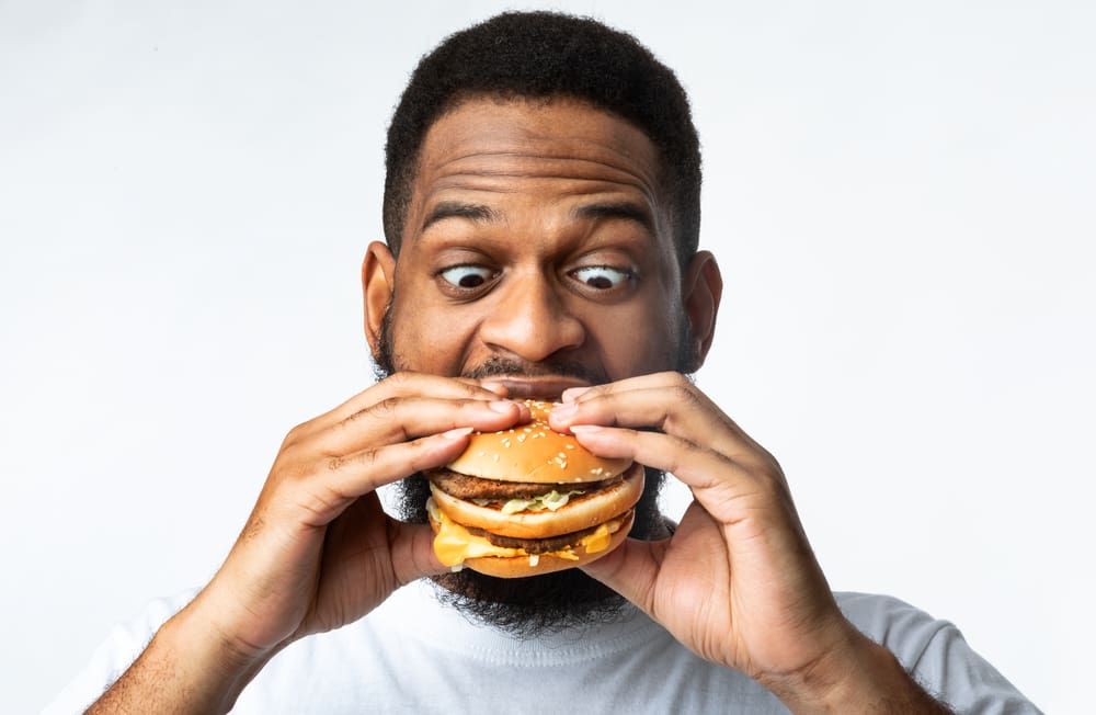 man eating burger; high protein diet